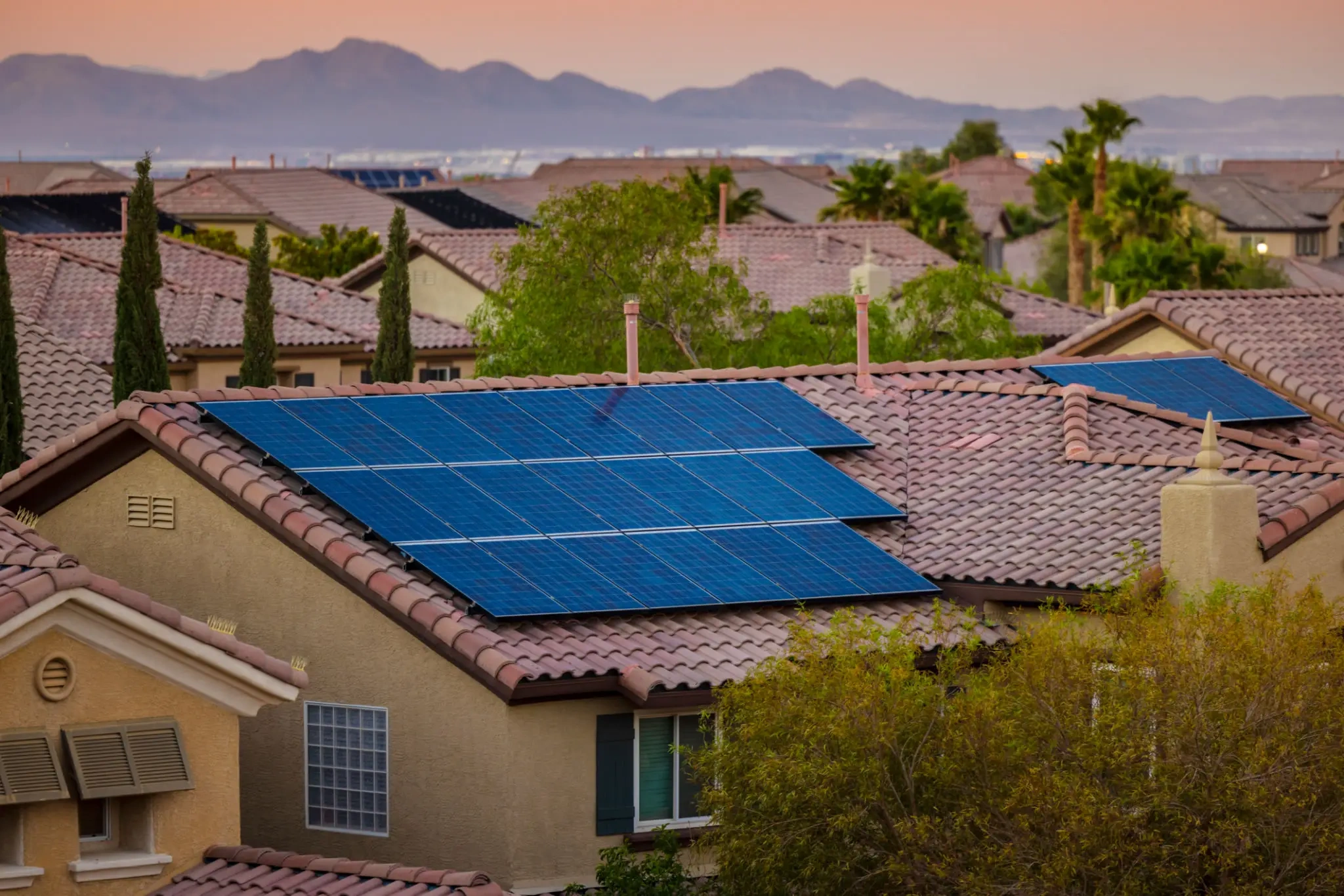 Houses with solar panels at sunset.